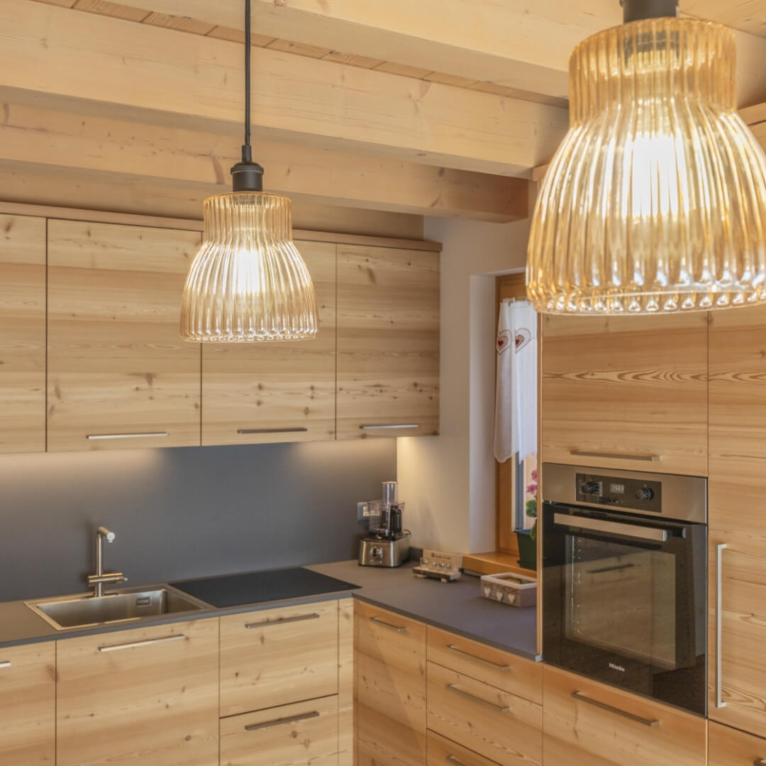 Cucina in legno di montagna e lampadari di vetro di design