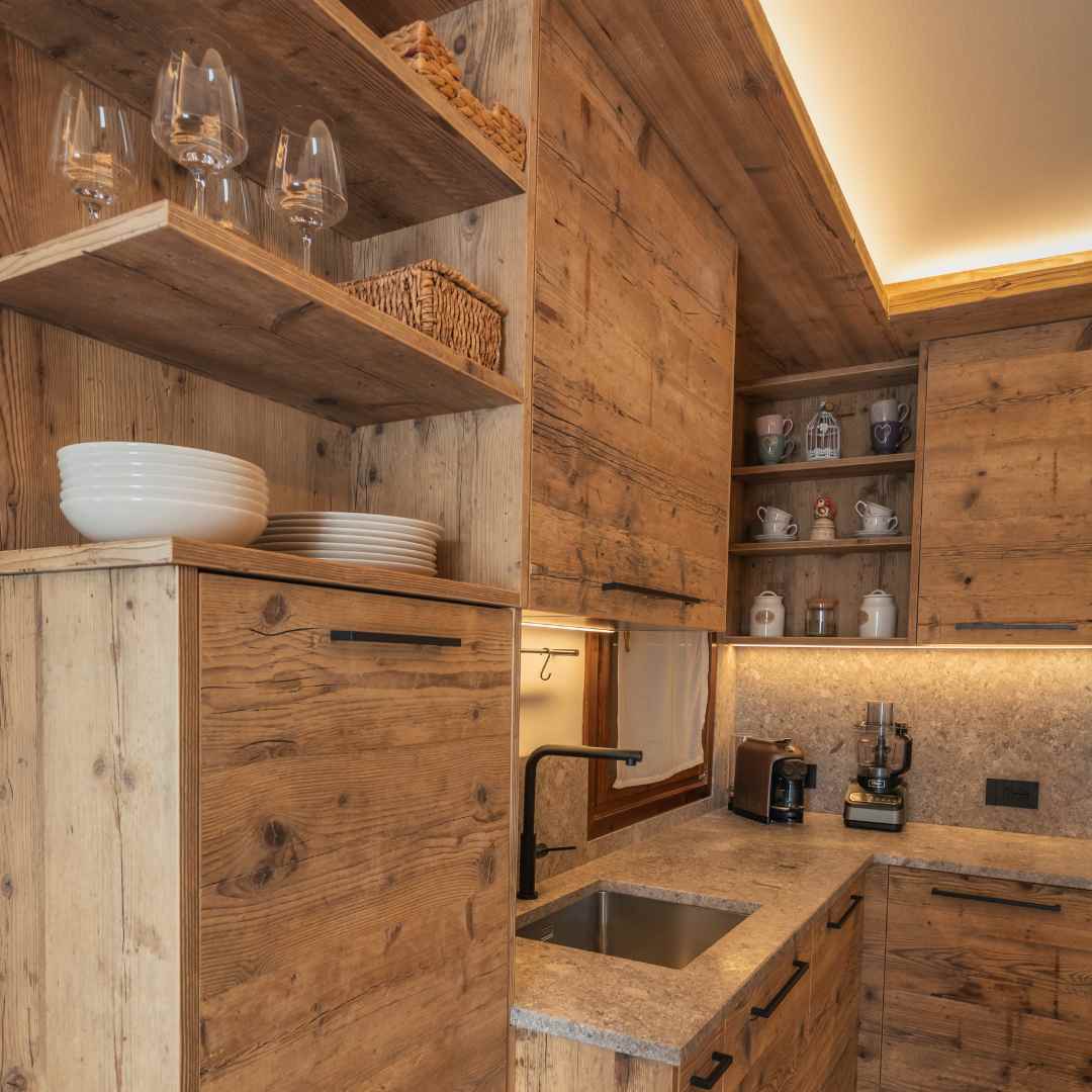 Cucina in legno di montagna su misura con illuminazione LED perimetrale e mensole aperte