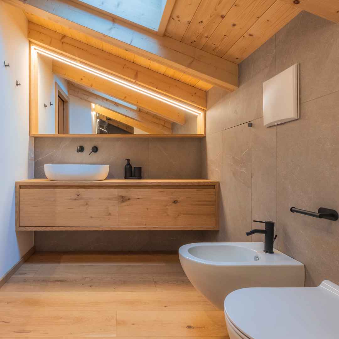 Bagno moderno di montagna con controsoffitto e mobile in legno