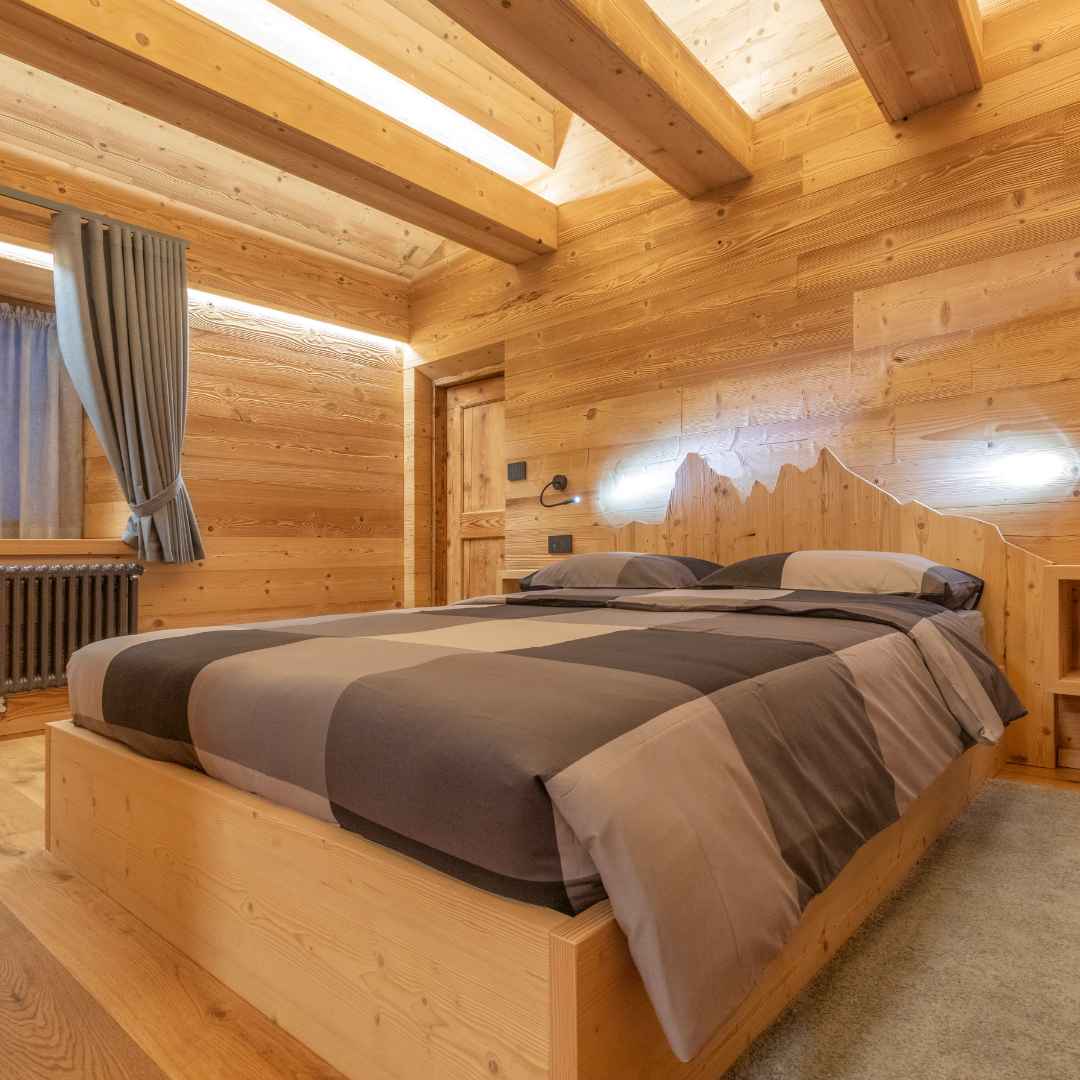 Stanza da letto in stile alpino con il profilo delle montagne come testata del letto