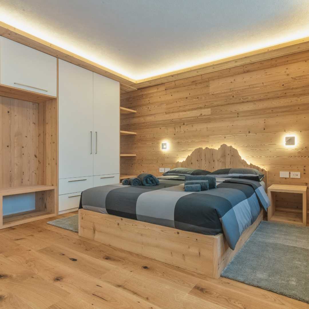 Camera di montagna con letto, pavimento e parete in legno e mobile ampio