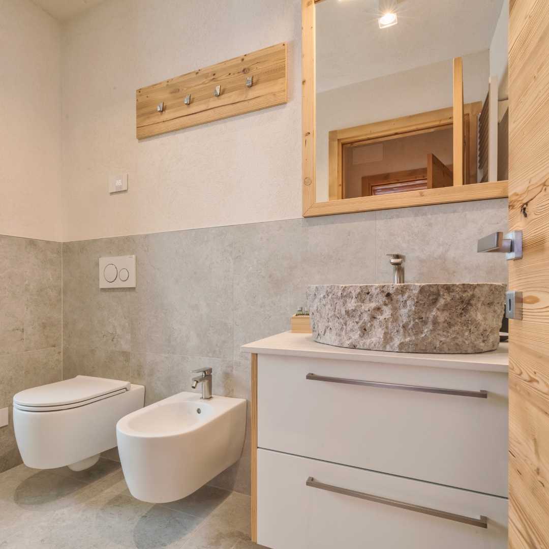 Bagno di montagna con lavabo in pietra ed elementi in legno