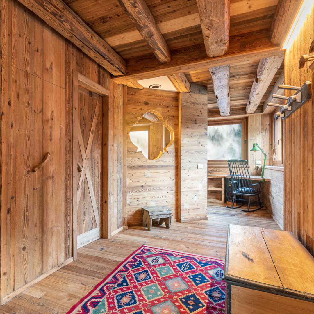Ingresso baita di montagna in legno con finestra decorativa