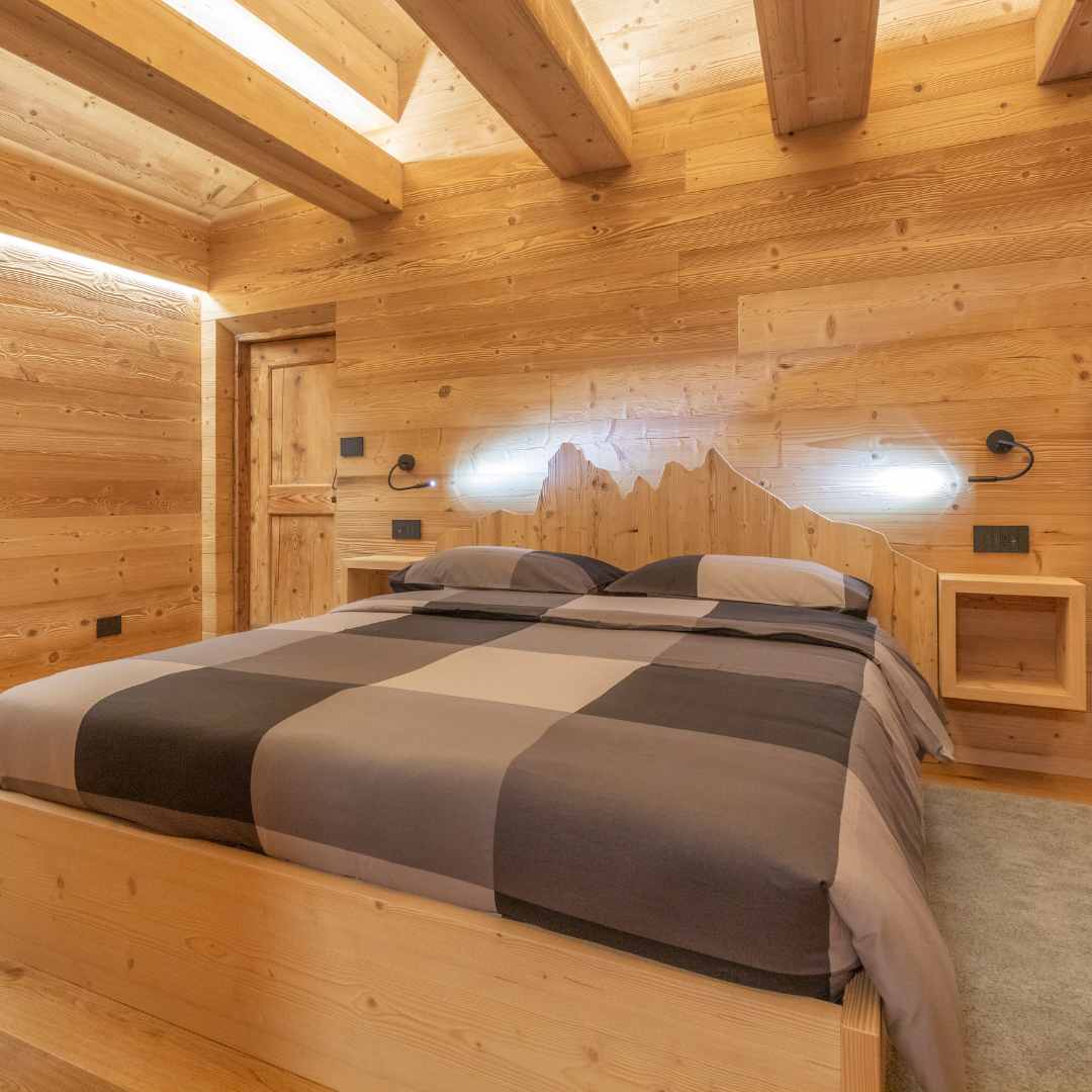 Letto in legno con testiera con profilo delle Alpe di Siusi