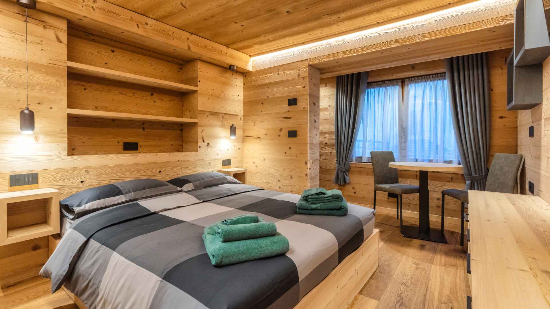 Camera da letto rivestita in legno con tavolo e sedie